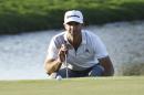 Dustin Johnson studies his second putt on the 18th green during the first round of the Cadillac Championship golf tournament in Doral, Fla., Thursday, March 5, 2015. (AP Photo/J Pat Carter)