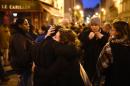 People take part in a gathering near Le Carillon restaurant, one of the sites of the attacks in Paris on November 14, 2015