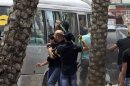 Hezbollah supporters attack a bus carrying anti-Hezbollah protesters in front of the Iranian embassy in Beirut