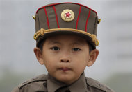 A boy wears a North Korean army hat near the Party Foundation Monument in the North Korean capital of Pyongyang October 11, 2010.  REUTERS/Petar Kujundzic