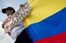 A woman with a Colombian national flag takes part in a march against the current peace talks with FARC rebels in Cali, Colombia on December 13, 2014