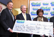 Louise White, right, 81 from Newport, R.I., is presented a check for $336 million by Gerald Aubin, left, director of the state's lottery, and Gov. Lincoln Chafee, center, at Rhode Island Lottery headquarters in Cranston, R.I., Tuesday, March 6, 2012. White won last month's $336.4 million Powerball jackpot, sleeping with the winning ticket in her Bible until coming forward to claim the sixth-largest U.S. prize on Tuesday, a family representative said. (AP Photo/Stew Milne)
