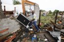Jason Moffett carries moves belongings out of a house which was destroyed after a series of tornadoes ripped through the Dallas suburb of Lancaster