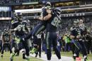 Seattle Seahawks running back Marshawn Lynch (24) celebrates with tight end Zach Miller (86) after running for a 31-yard touchdown against the New Orleans Saints during the fourth quarter of an NFC divisional playoff NFL football game in Seattle, Saturday, Jan. 11, 2014. (AP Photo/John Froschauer)