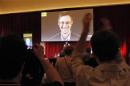 Supporters of Amnesty International cheer and shoot mobile phone videos as accused government whistleblower Snowden is introduced via teleconference during the Amnesty International Human Rights Conference 2014 in Chicago