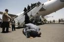 A Yemeni man, who was stranded in Egypt after conflict broke out in Yemen, prays and kisses the ground after arriving at Sanaa airport, Yemen, Wednesday, May 20, 2015. The airport was opened temporarily as two planes, one from India and one from Egypt, arrived carrying more than 300 Yemeni. (AP Photo/Hani Mohammed)