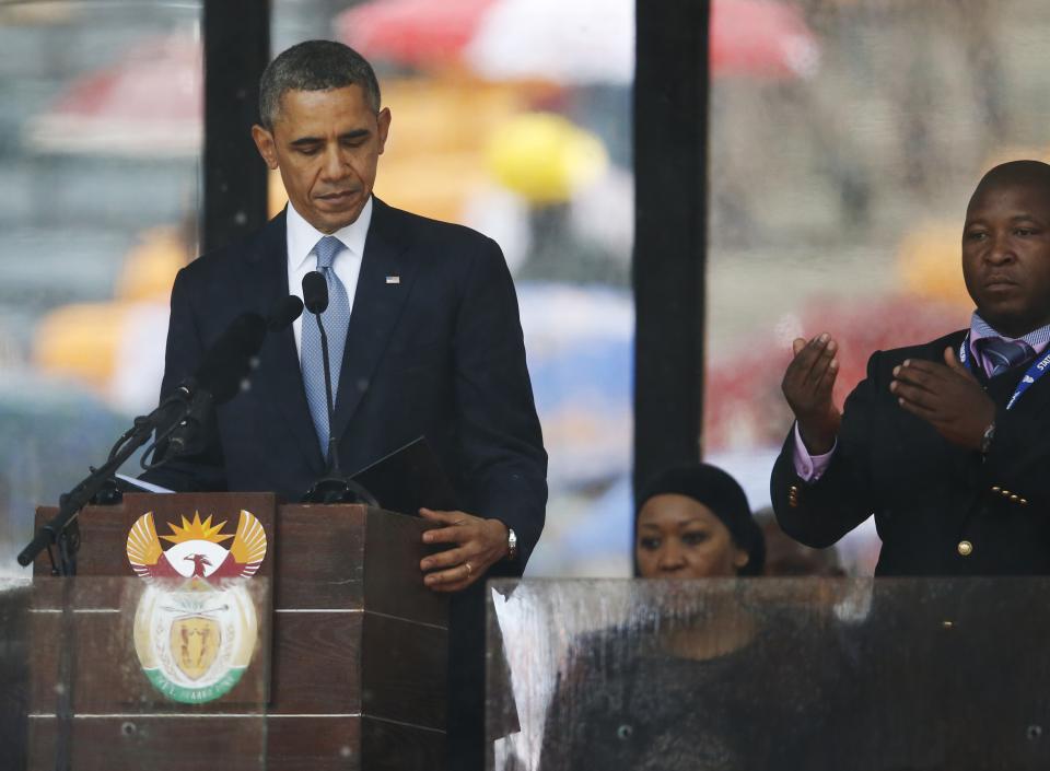 President Barack Obama looks down as he stands next to the sign language interpreter as he makes his speech at the memorial service for former South African president Nelson Mandela at the FNB Stadium in Soweto near Johannesburg, Tuesday, Dec. 10, 2013. South Africa&#39;s deaf federation said on Wednesday that the interpreter on stage for Mandela memorial was a &#39;fake&#39;, (AP Photo/Matt Dunham)