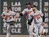 Baltimore Orioles left fielder Matt Angle (38), center fielder Adam Jones, and right fielder Nick Markakis (21) trot off the field after the Orioles defeated the Boston Red Sox 7-5 in a baseball game at Fenway Park in Boston, Tuesday, Sept. 20, 2011. (AP Photo/Elise Amendola)