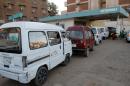 Drivers queue up in their vans for fuel at a gas station in the Sudanese capital Khartoum on December 21, 2013
