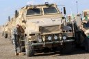 A US army soldier stands in front of a military vehicle ready to be shipped out of Iraq in 2011