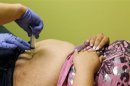 Registered Nurse Amanda Tyacke injects saline solution through the abdomen of Jazmine Raygoza, 17 (R) into an under-skin port which will fill Raygoza's Lap-Band at Rose Medical Center in Denver