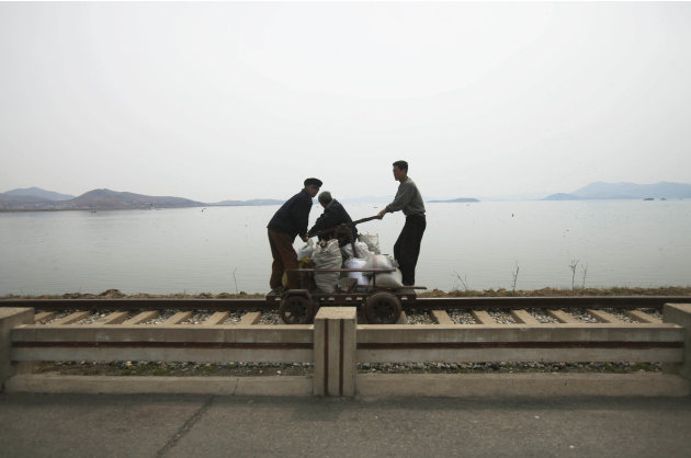 In this April 21, 2011 photo, men operate a manual rail car on tracks running along the West Sea barrage near Nampho, North Korea. (AP Photo/David Guttenfelder)