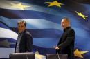 Outgoing Finance Minister Yanis Varoufakis shows newly-appointed Finance Minister Euclid Tsakalotos his chair in Athens
