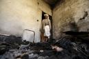 Man stands in room of house burnt after an air strike by a Saudi-led coalition struck a nearby missile base, in Yemen's capital Sanaa