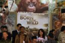 In this Monday, Feb. 20, 2012 photo, Indonesians stand in front of a poster of the movie 