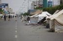 In this photo taken on Wednesday, Sept. 17, 2014, Hawthi Shiite protesters walk near tents at a sit-in in a main road leading to the airport in Sanaa, Yemen. Security officials say Shiite rebels have reached a suburb of Yemen's capital where they are fighting Sunni militias and besieging a university run by one of the nation's best known Sunni radicals. The officials say Thursday's fighting on Sept. 18, 2014 in Shamlan has forced thousands to flee their homes, but they have no word on casualties. They say the rebels, known as Hawthis, are surrounding the Iman University, an institution long viewed as a primary breeding ground for militants. (AP Photo/Hani Mohammed)