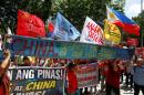 Demonstrators display a part of a fishing boat with anti-China protest signs during a rally outside the Chinese Consulate in Makati City