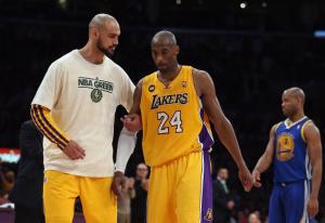 Kobe Bryant #24 of the Los Angeles Lakers is helped …
