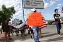 Marchers held signs as they made their way to Department of Homeland Security offices, protesting immigration policies Thursday, July 10, 2014, in El Paso, Texas. (AP Photo/El Paso Times, Victor Calzada)