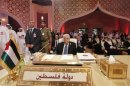 Palestinian President Mahmoud Abbas looks on during the opening of the Arab League summit in Doha