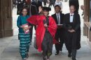 Myanmar pro-democracy leader Aung San Suu Kyi leaves through The Great Gate after receiving her honorary degree at Oxford University, in Oxford