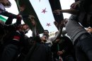 Anti-Syrian regime protesters stand beneath a Syrian revolution flag and chant slogans against Syrian President Bashar Assad during a demonstration after Friday prayers in Beirut, Friday, March 23, 2012. (AP Photo/Bilal Hussein)
