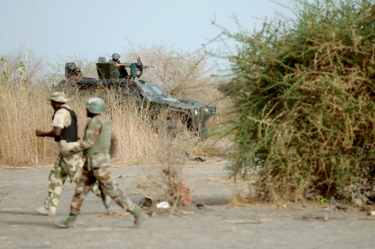 Nigerian soldiers patrol in the north of Borno state close to a Islamist extremist group Boko Haram former camp on June 5, 2013 near Maiduguri