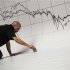 Worker puts finishing touches to a stage under a graph at the Madrid stock exchange