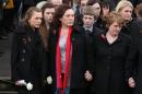 Kyra (L) and Yvonne (C), daughter and wife of David Black, 52, watch his coffin being carried away from the Molesworth Presbyterian Church during his funeral in Cookstown, Northern Ireland on November 6, 2012