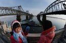 Chinese tourists view the Sino-Korean Friendship bridge on the Yalu River on February 8, 2013
