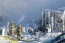 Canadian firefighters douse the burnt remains of a retirement home in L'Isle-Verte on January 23, 2014