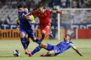 Aaron Ramsey (C) of Wales slips past a tackle from Cyprus' Constantinos Charalambides during their EURO 2016 qualifying match in Nicosia on September 3, 2015