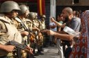Supporters of ousted Egyptian President Mohamed Mursi argue with riot police and army personnel during clashes near Rabaa Adawiya square