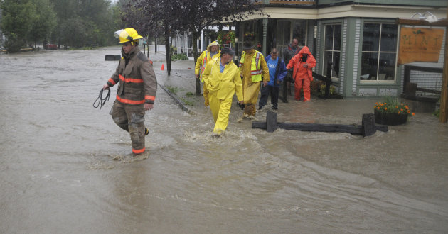 Waitsfield firefighters and rescuers wade through a street flooded by rain from Tropical Storm Irene after assisting residents in a building in Waitsfield, Vt., Sunday, Aug. 28, 2011. (AP Photo/Sandy 