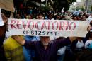 A man holds a banner reading "Recall" during a protest against new emergency powers decreed by President Nicolas Maduro, in Caracas on May 18, 2016