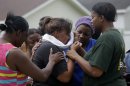 Lisa North, the mother of missing 6-year-old Ahlittia North, is comforted by her mother, Rene' Johnson, right, and others, after she says Jefferson Parish authorities have found the body of her daughter in a Harvey trash bin, in Harvey, La., Tuesday, July 16, 2013. Ahlittia disappeared from her apartment late Friday night or early Saturday morning. North's husband Albert Hill said they were told the body was found in a trash bin not far from their apartment. (AP Photo/Gerald Herbert)