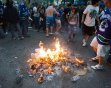 People watch a fire in Vancouver, British Columbia, on Wednesday, June 15, 2011. Parked cars were set on fire, others were tipped over and people threw beer bottles at giant television screens followi