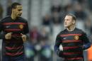 Manchester United's English defender Rio Ferdinand (L) and striker Wayne Rooney warm up in Munich on April 9, 2014