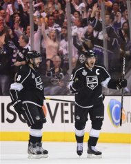 Los Angeles Kings right wing Dustin Brown (23) and Los Angeles Kings defenseman Drew Doughty (8) react after Brown scored his second goal of the first period against the New Jersey Devils during Game 6 of the NHL hockey Stanley Cup finals, Monday, June 11, 2012, in Los Angeles.  (AP Photo/Mark J. Terrill)