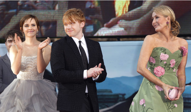 British author JK Rowling, right, looks on as actors, left, Emma Watson and Rupert Grint, applaud the crowd at Trafalgar Square, Thursday, July 7, 2011. Harry Potter's saga is ending, but his magic sp