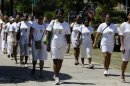 Members of dissident group Ladies in White take part in their weekly march in front of Santa Rita church in Havana, Cuba, Sunday March 18, 2012. Dissident Angel Moya says police detained his wife Bertha Soler and three dozen supporters of the Ladies in White dissident group on Sunday morning. The detentions come just over a week ahead of a visit by Pope Benedict XVI, who is likely to bring up the issue of religious, political and human rights during his tour. The image of the woman on their shirts is of Laura Pollan, the group's former leader who died in 2011 of a heart attack. (AP Photo/Franklin Reyes)