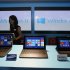 FILE - In this Friday, Oct. 26, 2012, file photo, a woman walks past laptop computers running Microsoft Windows 8 operating system during its launching ceremony in Hong Kong. Research firm IDC says PC global shipments of PCs fell 14 percent in the first three months this year. The appeal of tablets and smartphones is pulling money away from PC sales, but it also blames Microsoft's latest version of Windows, which forces users to learn new ways to control their machines. (AP Photo/Kin Cheung, File)