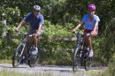 President Barack Obama and daughter Malia ride their bikes in Manuel F. Correllus State Forest in West Tisbury, Mass., after first lady Michelle Obama, with daughter Sasha, passed by first, Friday, Aug. 16, 2013, during their family vacation on the island of Martha's Vineyard. (AP Photo/Jacquelyn Martin)