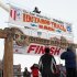 Volunteers hang a banner above the burled arch, which serves as the finish line for the 1,000-mile Iditarod Trail Sled Dog Race in Nome, Alaska, on Monday, March 11, 2013. The race began March 3 in Willow, Alaska, and some race watchers predict a Tuesday finish. (AP Photo/Mark Thiessen)