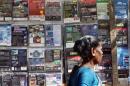Woman walks past pirated DVDs and software on sale in Mumbai