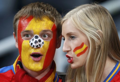 Fansof Spain's soccer team with their faces painted in colors of national flag cheer before Euro 2012 semi-final soccer match against Portugal at Donbass Arena in Donetsk