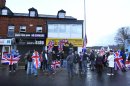 Loyalists hang Union flags during a protest outside the offices of a member of the Alliance Party in east Belfast