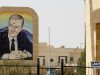 A portrait of former Syrian President Hafez al-Assad on a bullet-riddled facade is seen at the Rabia border crossing, the main border post between Iraq and Syria