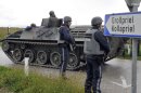 Austrian army soldiers in an armored vehicle arrive near the villages of Grosspriel and Kollapriel some 90 kilometers (55 miles) west of Vienna, Austria, Tuesday, Sept. 17, 2013, where a man is barricading himself inside a farm building after he killed two police officers and the driver of an emergency rescue vehicle as the dpa news agency said, citing an unidentified police spokesman. Interior Minister spokesman Karl-Heinz Grundboeck said a third police officer was apparently being held by the shooter in the village of Kollapriel. He confirmed that three people were shot but refused to say whether their injuries were fatal, explaining that officials did not want to give the gunman information through news reports he was likely monitoring. (AP Photo/Hans Punz)