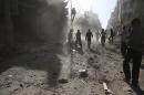 Residents inspect damage after what activists said was an airstrike by forces loyal to Syria's President Bashar al-Assad on the town of Douma, eastern Ghouta of Damascus